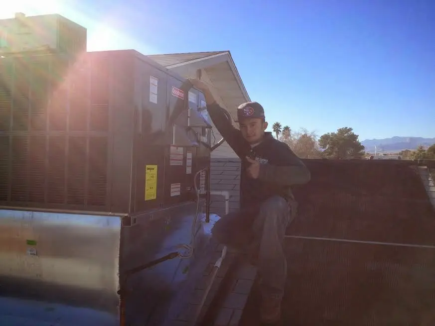 HVAC technician performing Heat Pump Repair on a rooftop unit in Seagoville
